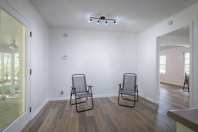 living area featuring ceiling fan, ornamental molding, a textured ceiling, and hardwood / wood-style flooring