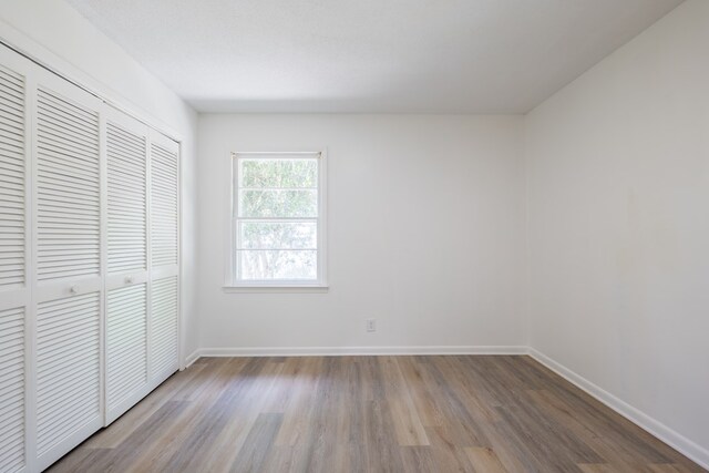 unfurnished bedroom featuring light hardwood / wood-style floors and a closet