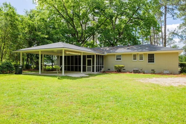 back of property featuring a yard, central AC, a carport, and a sunroom