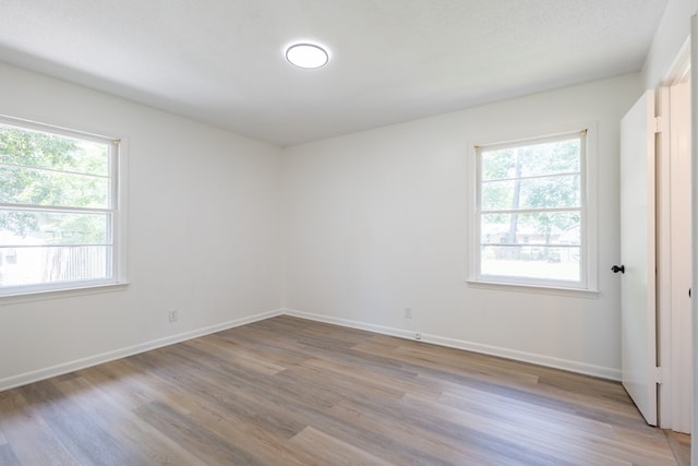 empty room featuring a textured ceiling and light wood-type flooring