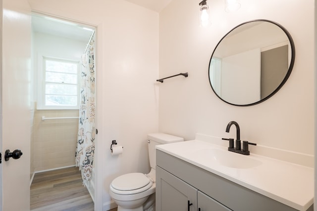 bathroom featuring vanity, hardwood / wood-style flooring, toilet, and walk in shower