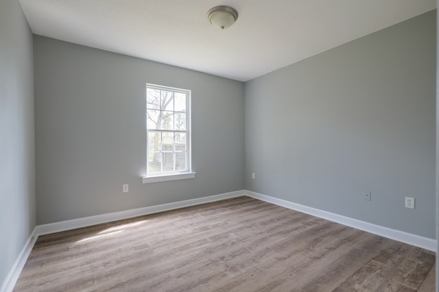 spare room with wood finished floors and baseboards