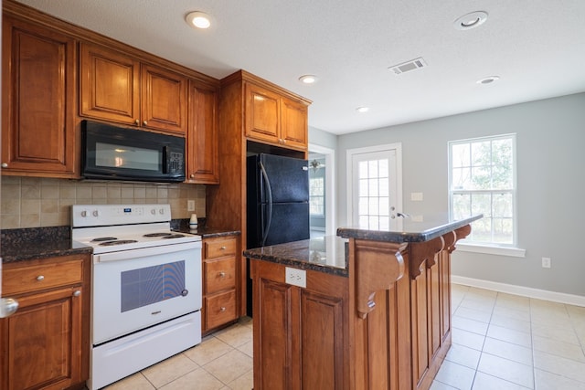 kitchen with visible vents, brown cabinetry, a kitchen island, black appliances, and backsplash