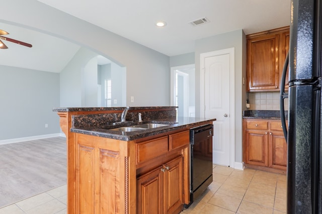 kitchen with arched walkways, tasteful backsplash, visible vents, a sink, and black appliances