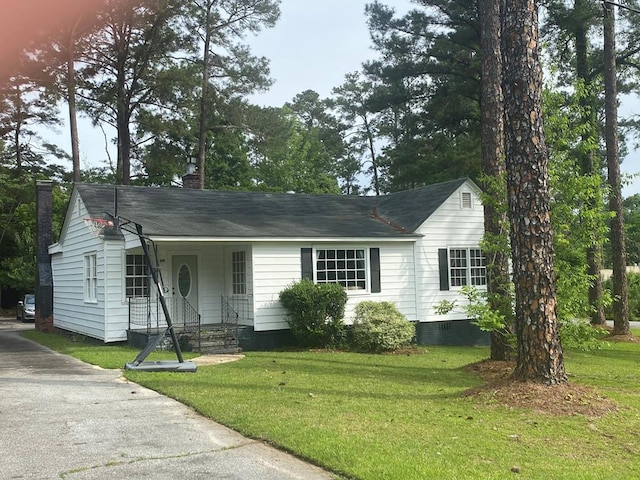 single story home featuring a shingled roof, a front lawn, crawl space, and a chimney