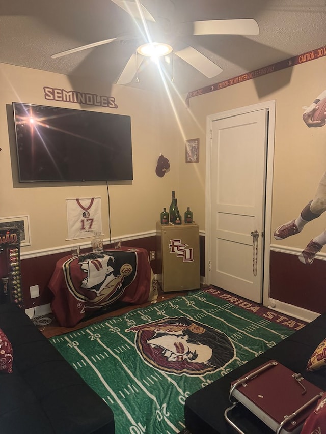 bedroom with a ceiling fan, carpet flooring, and a textured ceiling