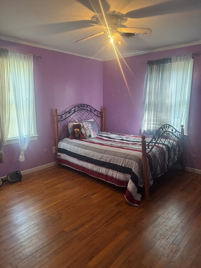 bedroom featuring wood-type flooring, ornamental molding, baseboards, and ceiling fan