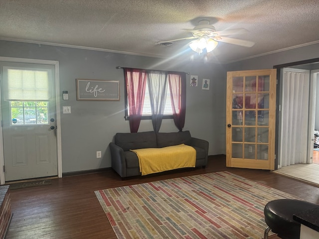 living room with crown molding, ceiling fan, a textured ceiling, and wood finished floors