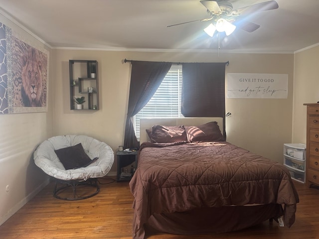 bedroom with baseboards, ceiling fan, ornamental molding, and wood finished floors