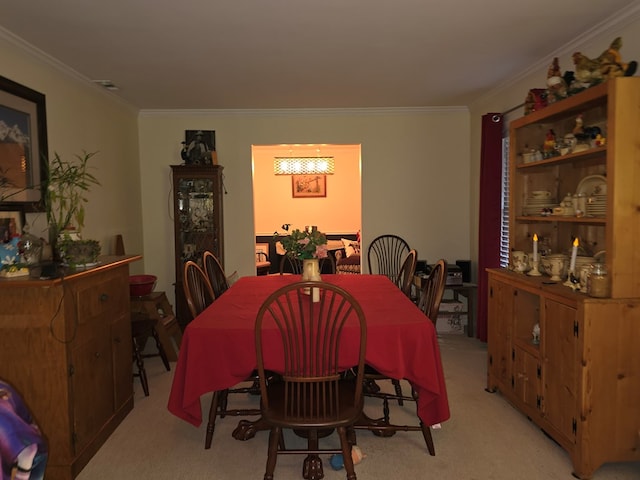 carpeted dining room featuring crown molding