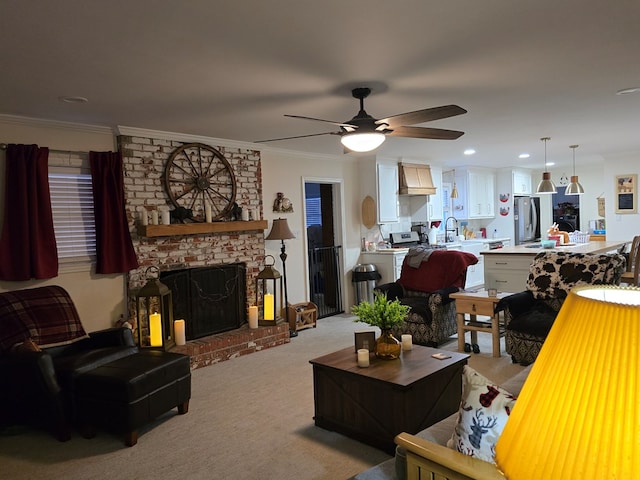 carpeted living room with crown molding, sink, ceiling fan, and a fireplace