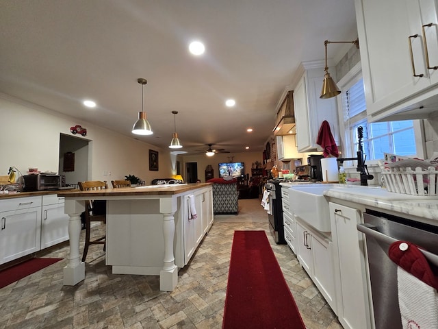 kitchen featuring a breakfast bar, appliances with stainless steel finishes, a center island, white cabinets, and decorative light fixtures