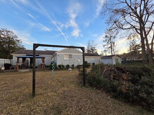 rear view of property with a gazebo and a lawn