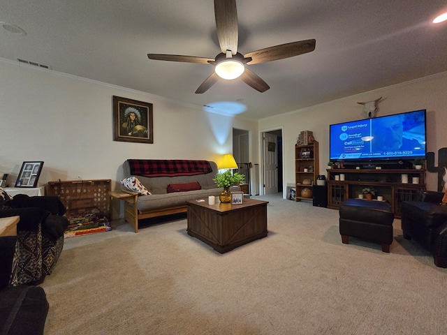 living room with ornamental molding, ceiling fan, and carpet flooring