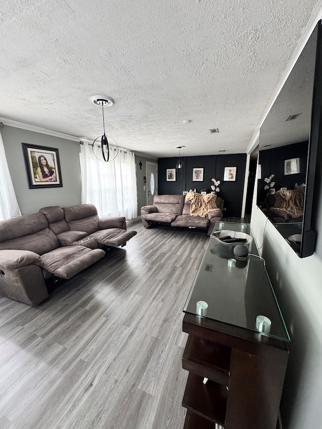living room with wood finished floors, a textured ceiling, and visible vents