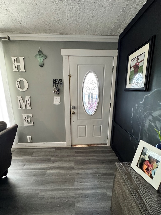 foyer entrance featuring wood finished floors, a textured ceiling, and ornamental molding