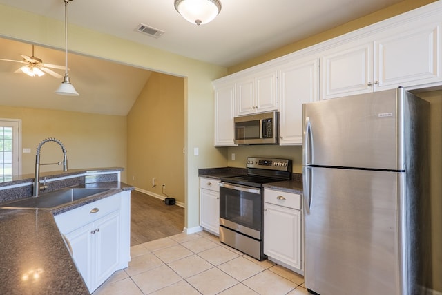 5702 Emily Ln, Hahira, GA 31632 - kitchen with stainless steel appliances, a sink, white cabinets, hanging light fixtures, and lofted ceiling