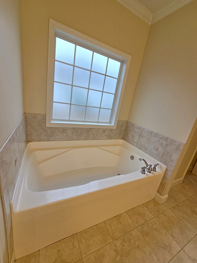 bathroom with a tub to relax in, crown molding, and tile patterned floors