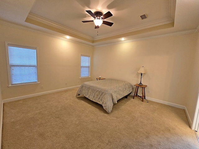 carpeted bedroom with crown molding, ceiling fan, and a tray ceiling