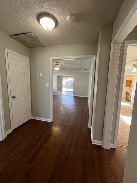 hallway with dark hardwood / wood-style flooring and a textured ceiling