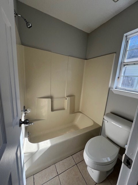 bathroom with bathtub / shower combination, tile patterned floors, toilet, and a textured ceiling