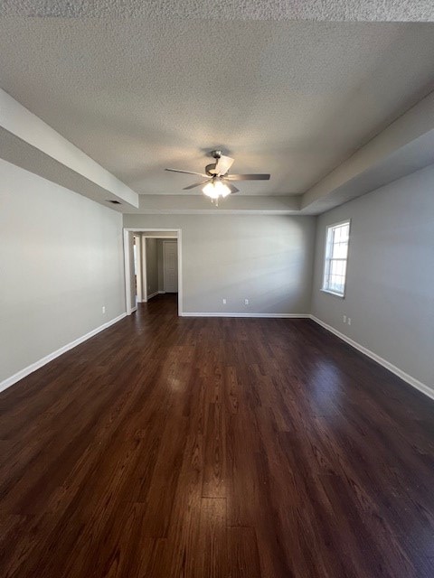 spare room featuring ceiling fan, a textured ceiling, and dark hardwood / wood-style flooring