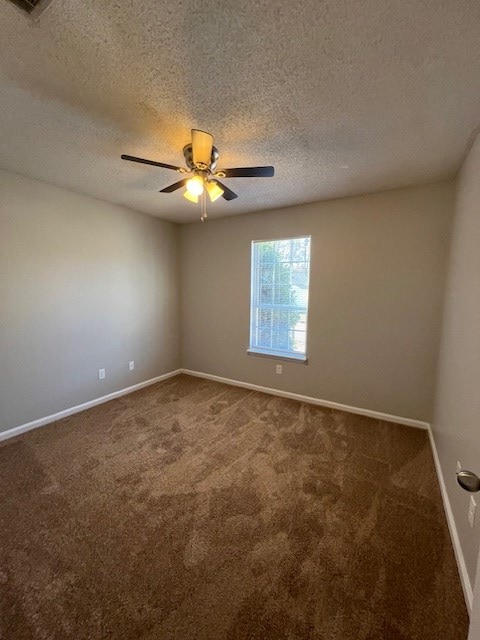 carpeted empty room featuring a textured ceiling and ceiling fan