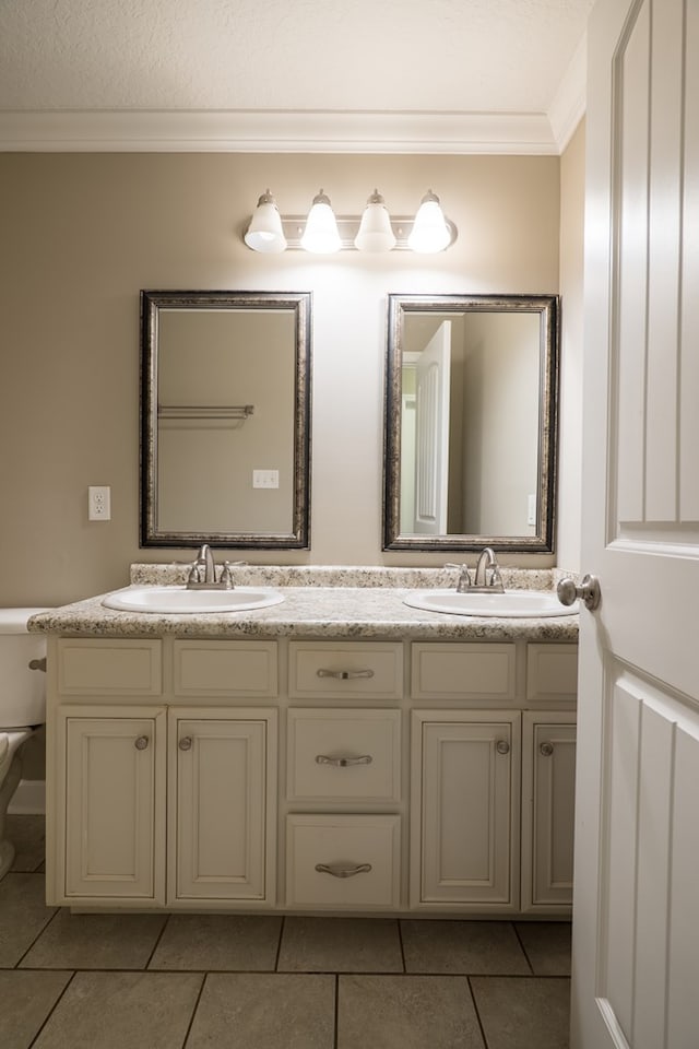 bathroom with tile patterned flooring, vanity, toilet, and crown molding