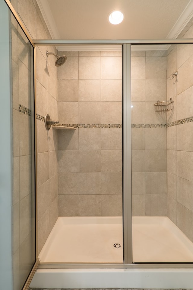 bathroom featuring an enclosed shower and ornamental molding