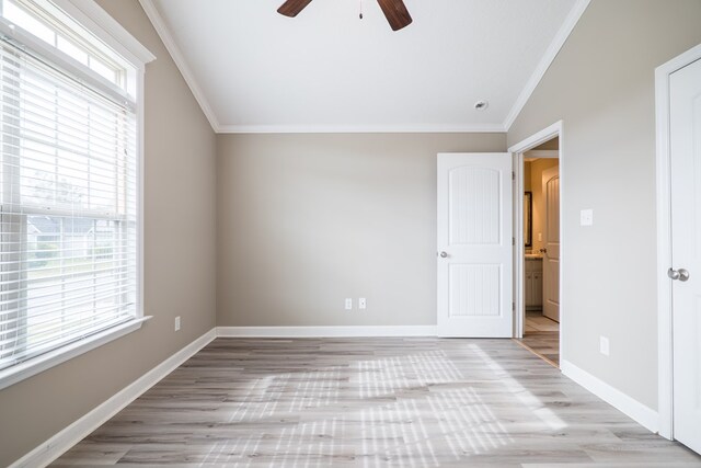 unfurnished bedroom featuring light wood-type flooring, multiple windows, ornamental molding, and ceiling fan