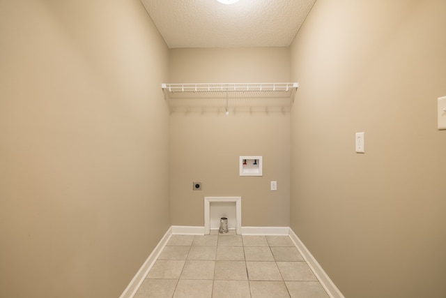 laundry room with electric dryer hookup, light tile patterned floors, a textured ceiling, and hookup for a washing machine