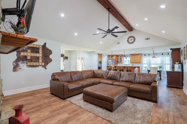 living room with baseboards, visible vents, beam ceiling, ceiling fan, and light wood finished floors