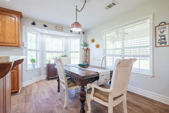 dining room with light wood-style floors, baseboards, and visible vents