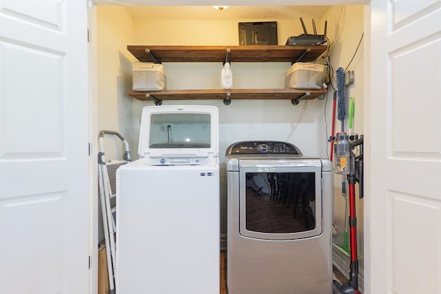 clothes washing area with washer and clothes dryer and laundry area