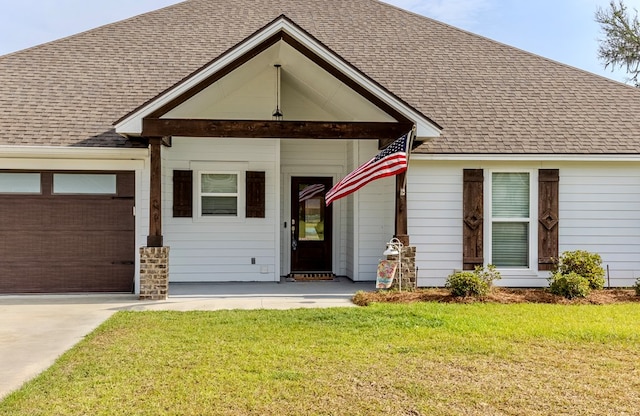 view of front of house with a garage, a front lawn, concrete driveway, and roof with shingles