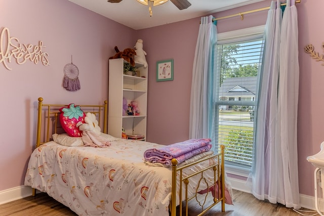 bedroom with baseboards, wood finished floors, and ceiling fan