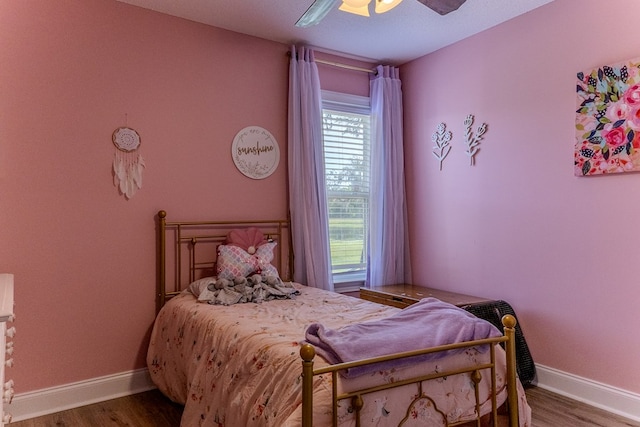 bedroom with baseboards, wood finished floors, and a ceiling fan