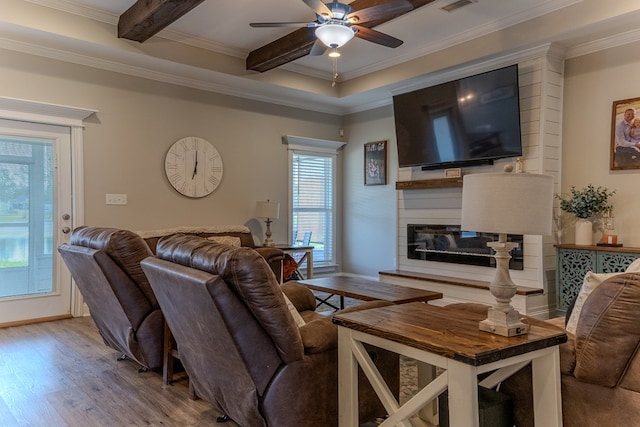 living room with crown molding, ceiling fan, wood finished floors, and a fireplace