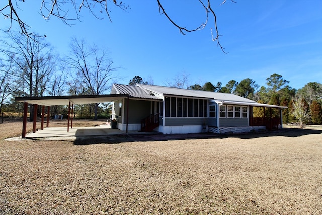 rear view of house featuring a carport and a sunroom