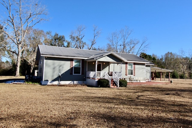 view of front of property featuring a porch, a patio, and a front yard