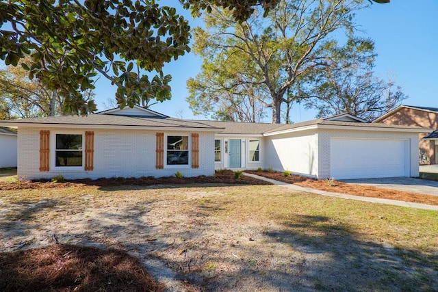 ranch-style home featuring concrete driveway, a garage, brick siding, and a front lawn