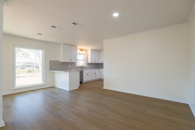 kitchen featuring tasteful backsplash, dishwasher, light countertops, wood finished floors, and a sink