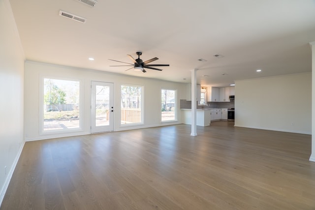 unfurnished living room with a ceiling fan, wood finished floors, visible vents, and baseboards