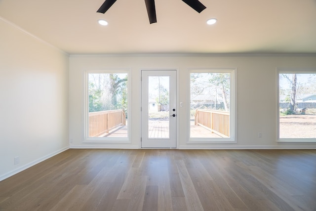 interior space with a wealth of natural light, wood finished floors, and ornamental molding