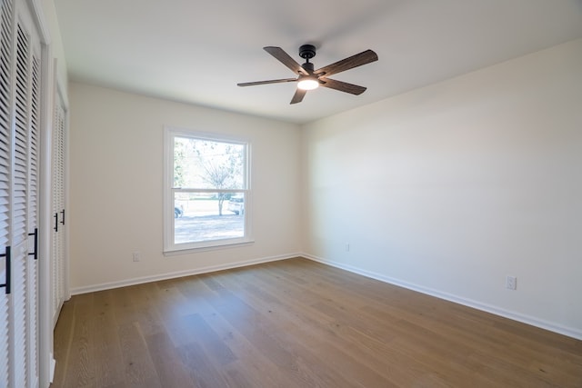 unfurnished bedroom featuring baseboards, wood finished floors, and a ceiling fan