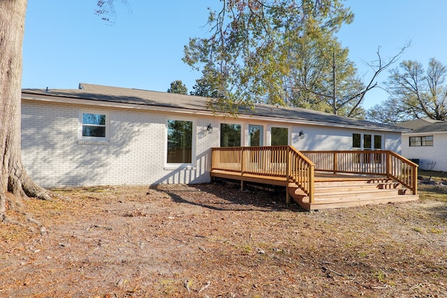 rear view of property with a deck and brick siding