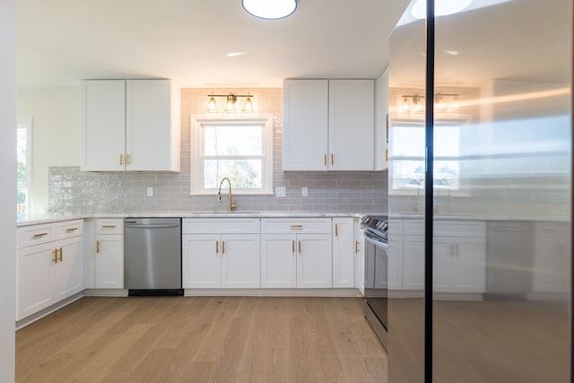 kitchen with white cabinetry, light wood finished floors, appliances with stainless steel finishes, and a sink