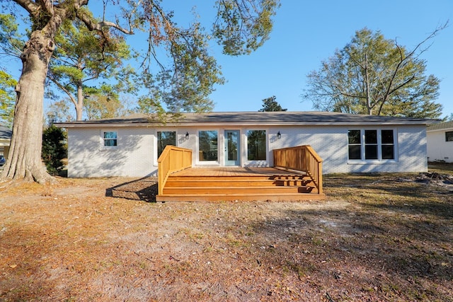 back of property with brick siding and a wooden deck