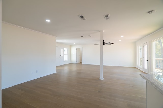 unfurnished living room featuring visible vents, wood finished floors, recessed lighting, crown molding, and baseboards