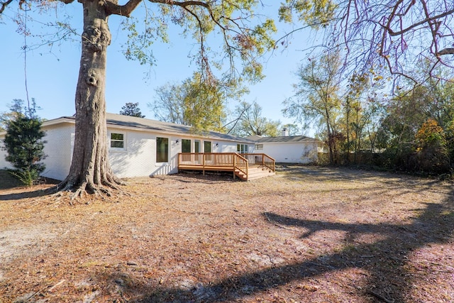 back of property with brick siding and a deck